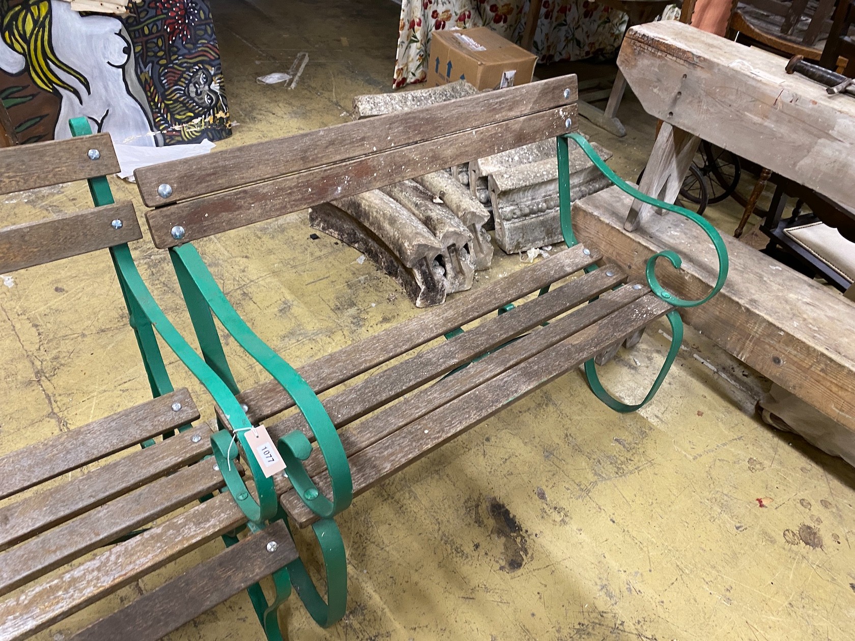 A near pair of painted wrought iron slatted wooden garden benches, larger length 137cm, depth 74cm, height 88cm